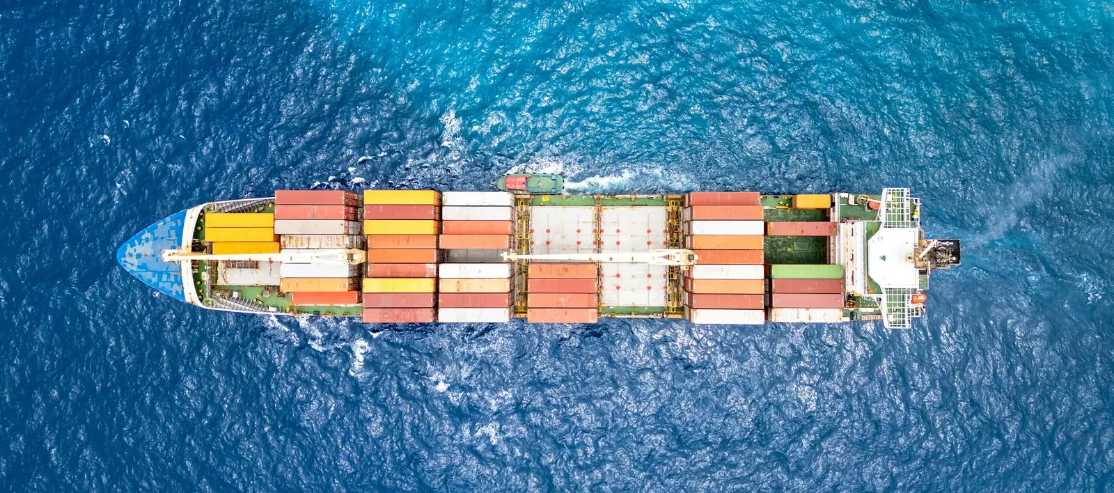 A container ship at sea, seen from directly above
